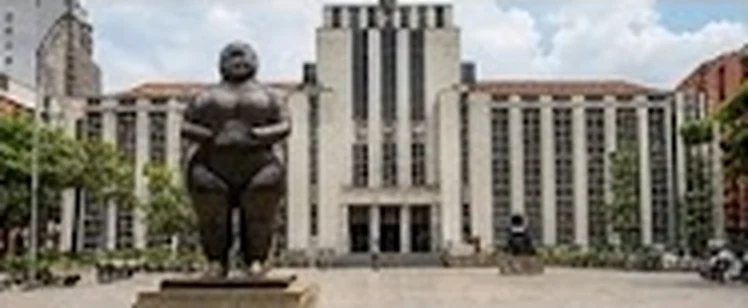 Escultura de Botero frente a edificios de la Plaza Botero