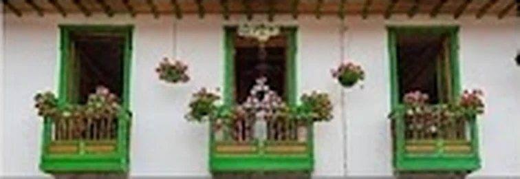 Balcones verdes con flores en una fachada de Jericó